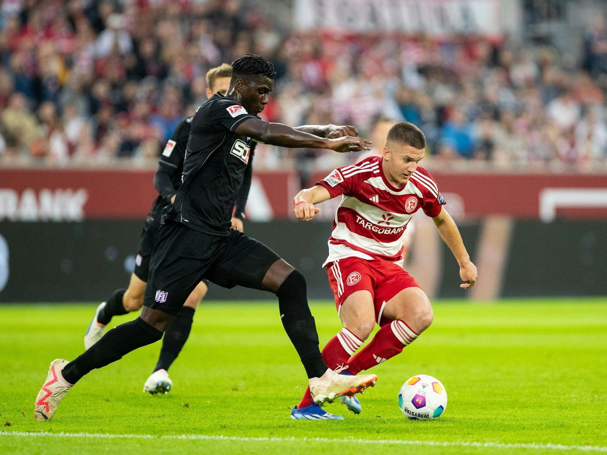 Fortuna Düsseldorfs Christos Tzolis im Zweikampf mit Osnabrücks Maxwell Gyamfi.