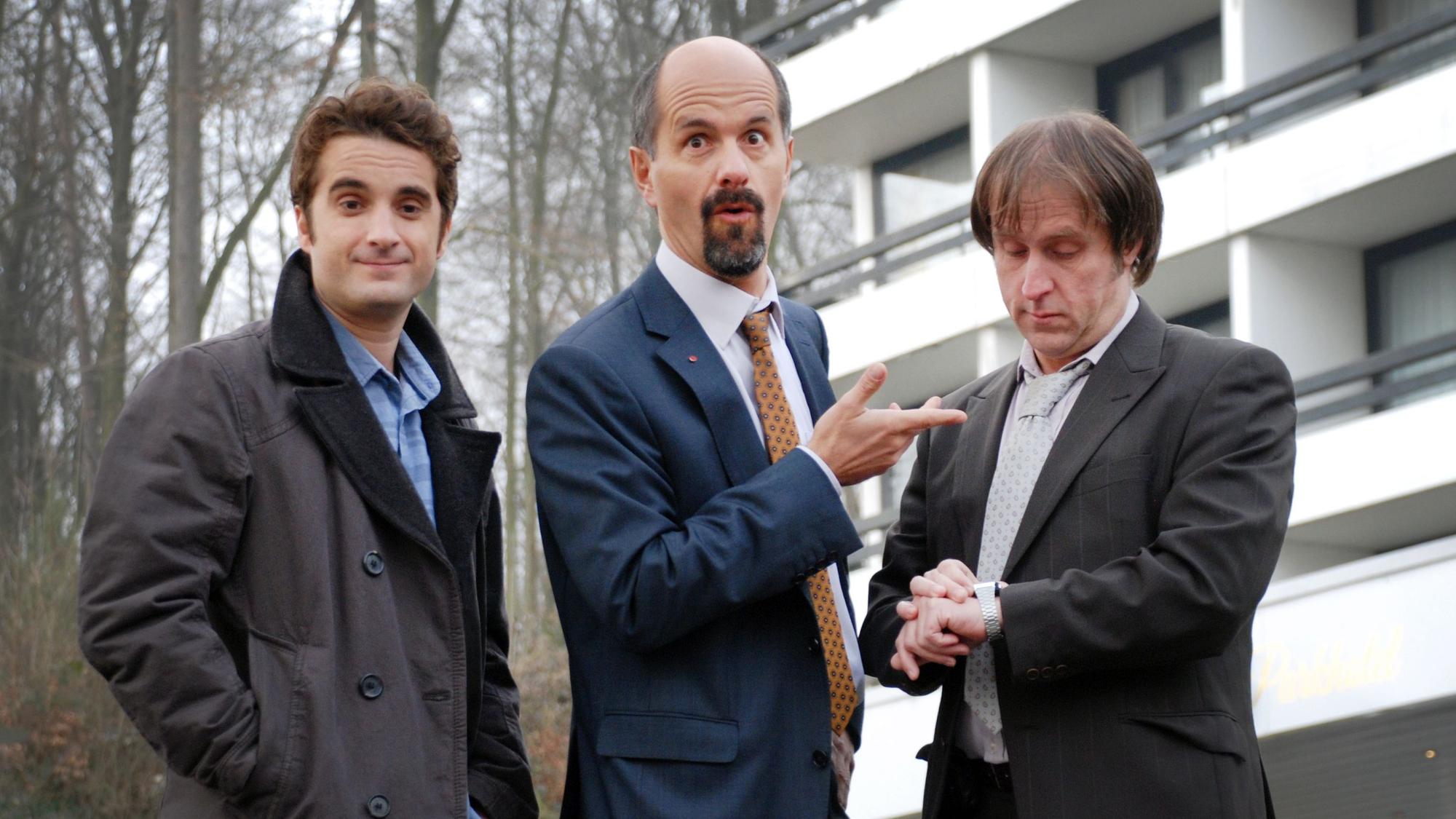 Oliver Wnuk, Christoph Maria Herbst und Bjarne Mädel stehen vor einem Haus.