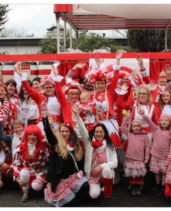 Mitglieder vom FMK lächeln beim Karnevalsumzug in Merheim in die Kamera.
