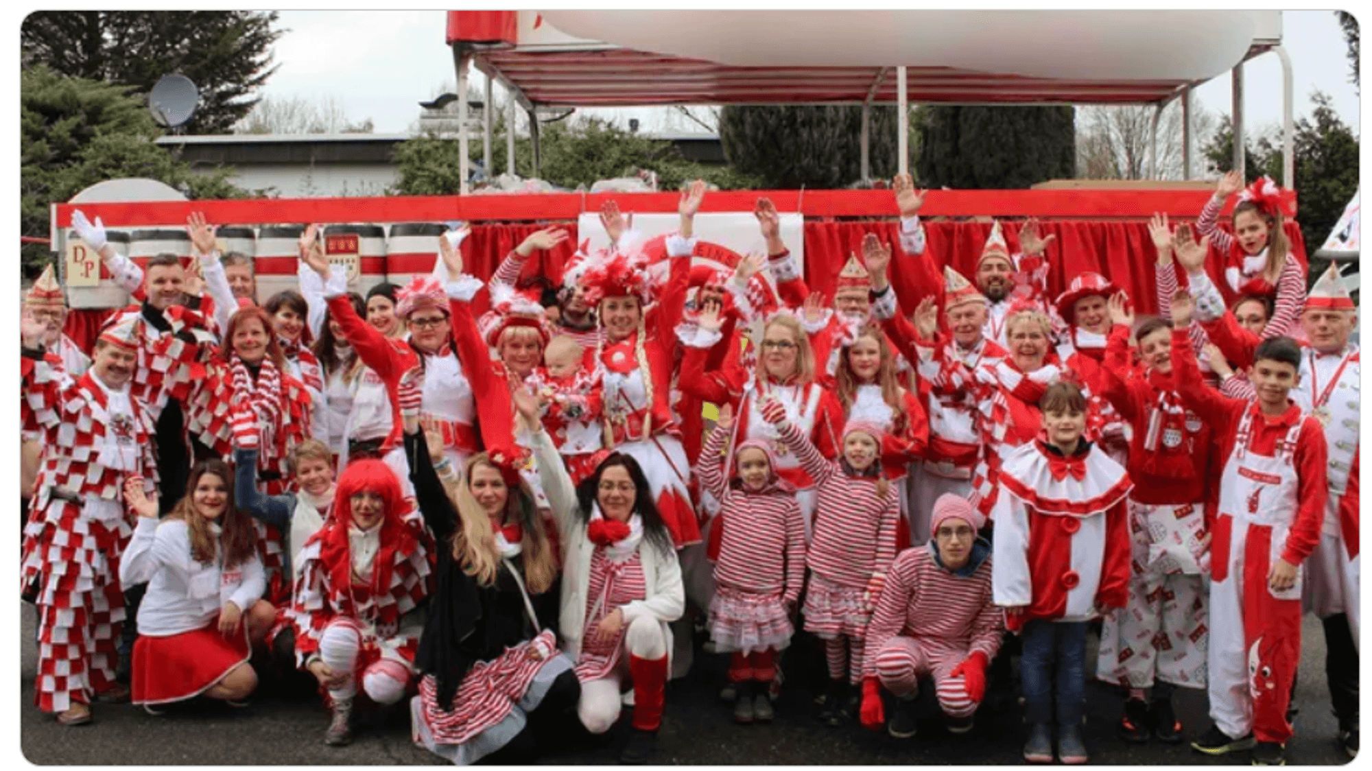 Mitglieder vom FMK lächeln beim Karnevalsumzug in Merheim in die Kamera.