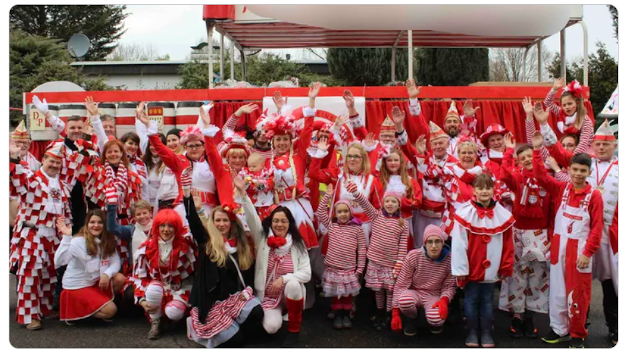 Mitglieder vom FMK lächeln beim Karnevalsumzug in Merheim in die Kamera.