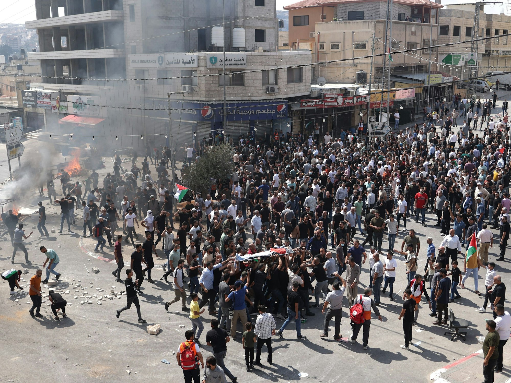 Palästinenser tragen am 6. Oktober 2023 in Huwara (palästinensisches Gebiet) den Leichnam eines 19-jährigen Palästinensers, der bei einem nächtlichen Angriff erschossen wurde, während seiner Beerdigung.