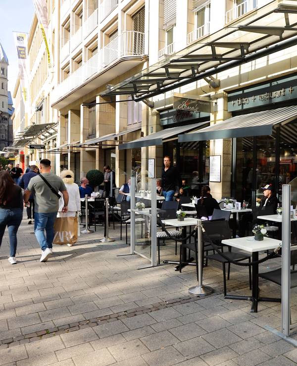 Blick von außen auf das Bistro Diner's am Neumarkt in Köln. Stühle und Tische sind vor dem Lokal aufgebaut.