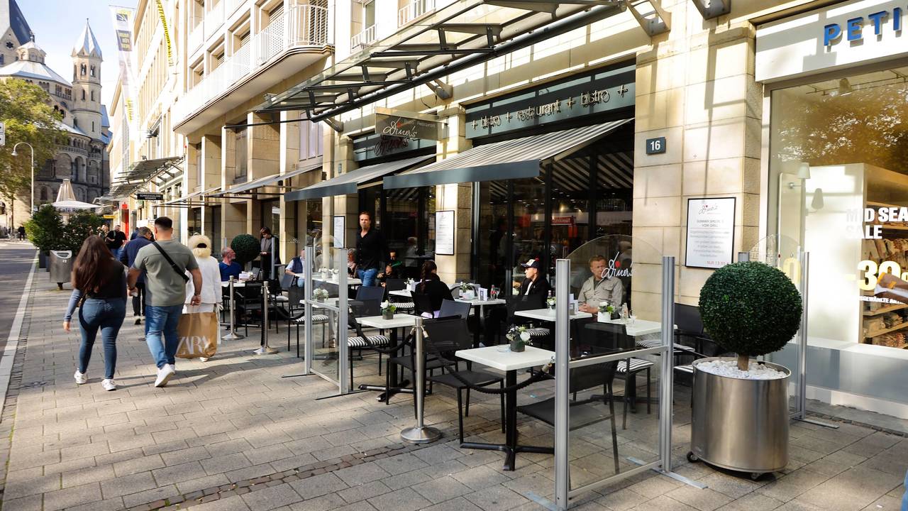 Blick von außen auf das Bistro Diner's am Neumarkt in Köln. Stühle und Tische sind vor dem Lokal aufgebaut.