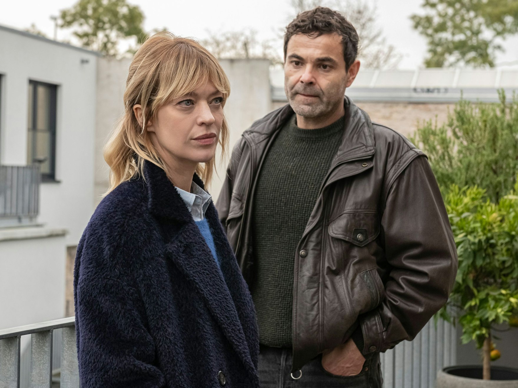 Heike Makatsch und Andreas Döhler stehen (in ihren Rollen) vor einem Haus.