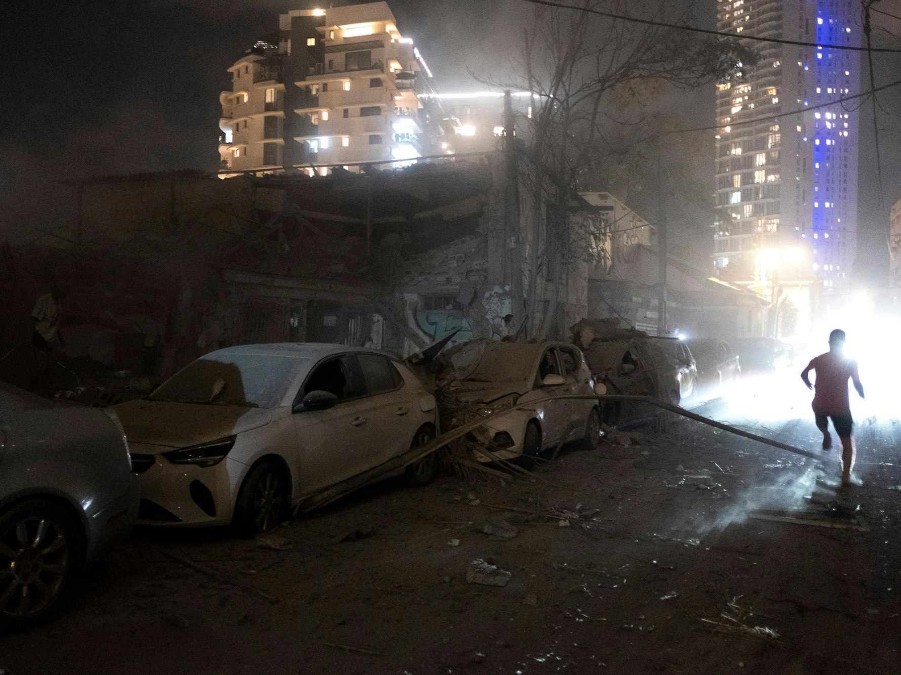 Menschen gehen am 7. Oktober 2023 in Tel Aviv an den Schäden einer aus dem Gazastreifen abgefeuerten Rakete vorbei.