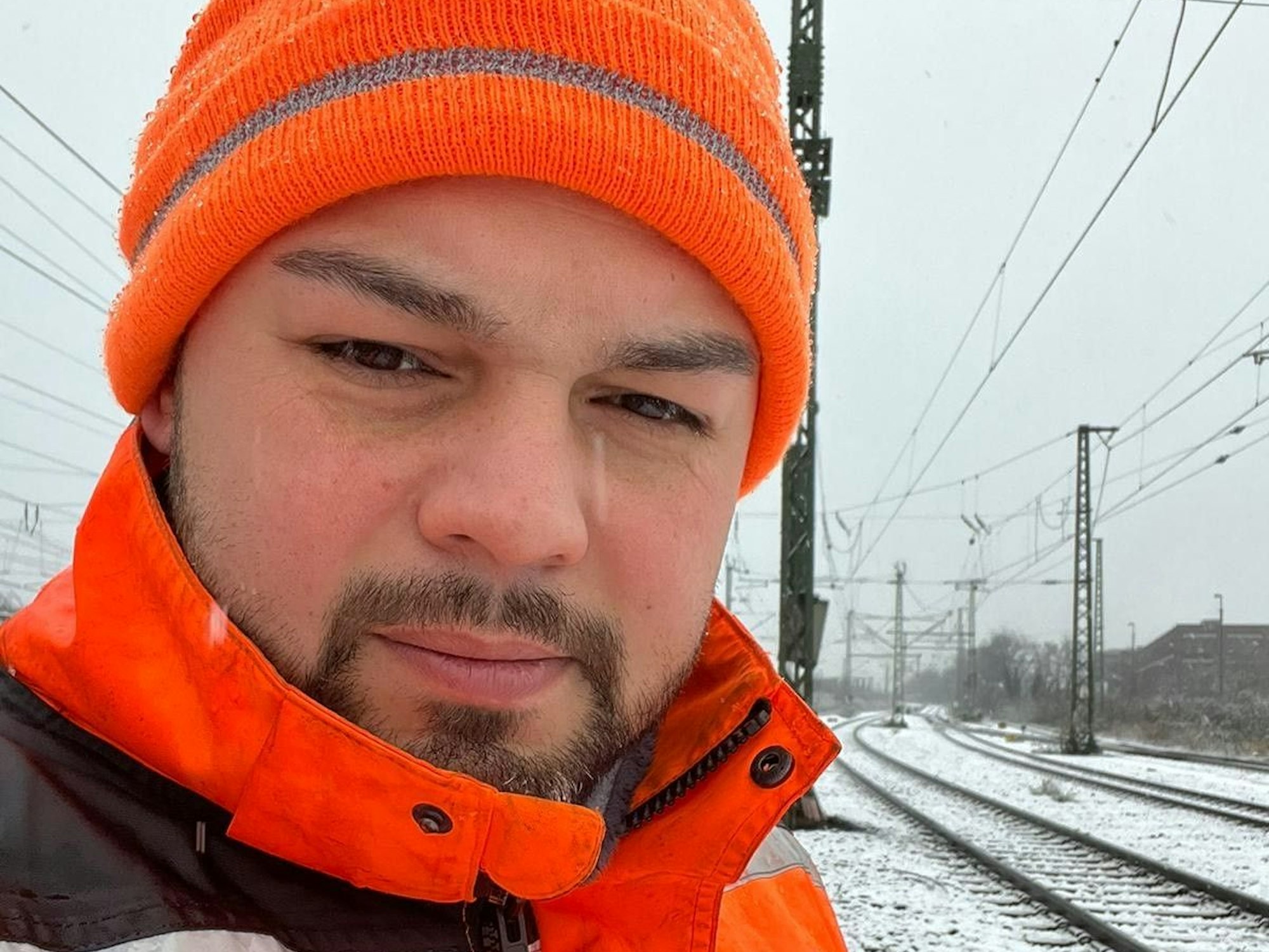 Ali Ceyhan steht an Bahngleisen.