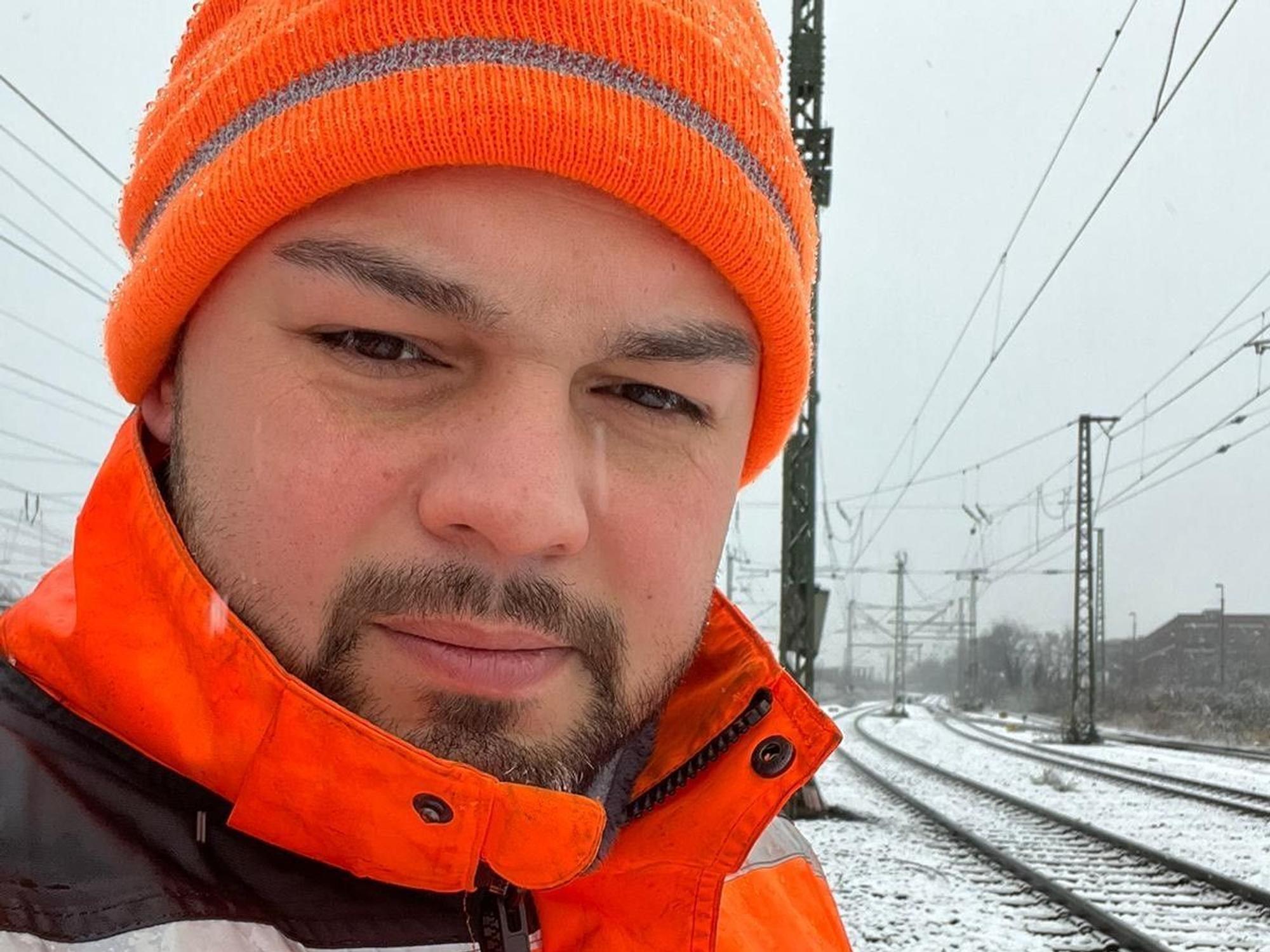 Ali Ceyhan steht an Bahngleisen.