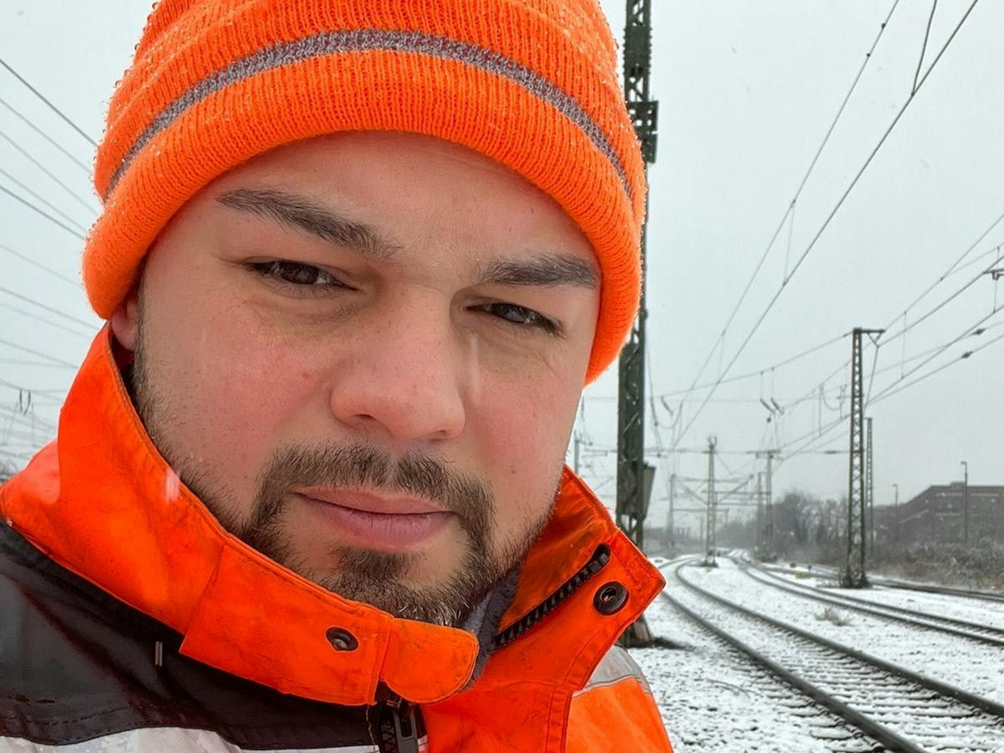 Ali Ceyhan steht an Bahngleisen.