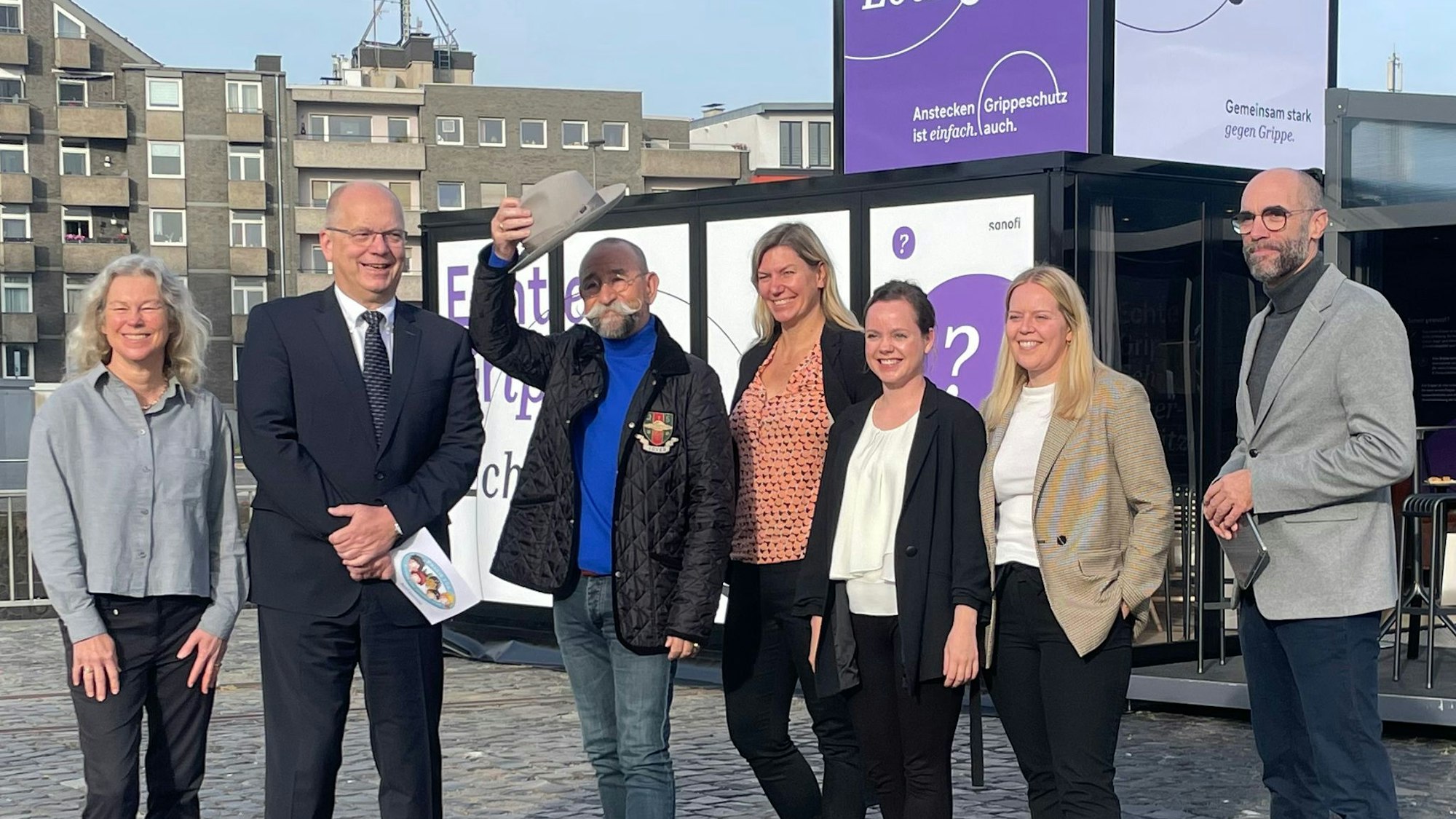 Moderator und Fernsehkoch Horst Lichter steht unter anderem mit Arzt und Impfspezialist Ralph Köllges (2. v. l.) und Dr. Barbara Keck, Geschäftsführerin BAGSO (l.) vor der NoFluenza Lounge in Köln.