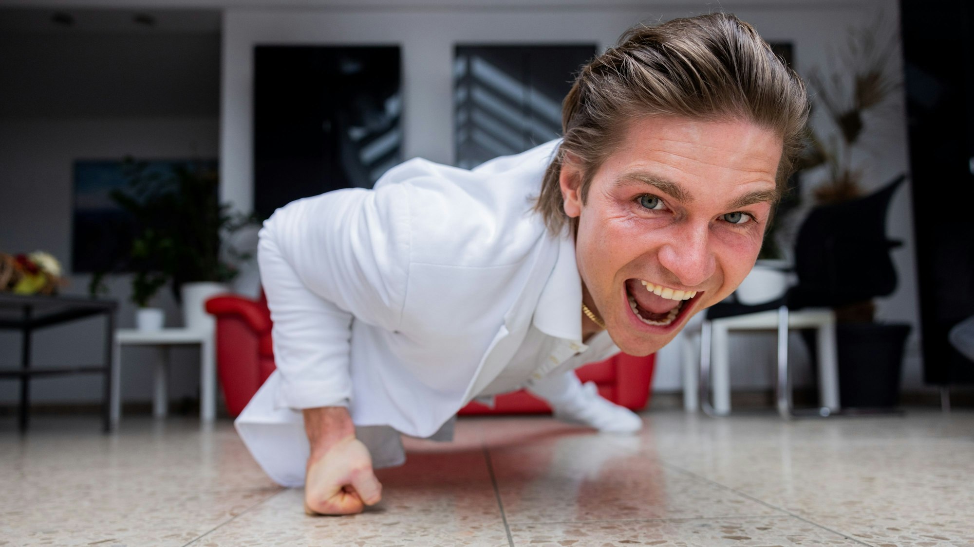 Jeremy Fragrance macht Liegestützen mit einem Arm.