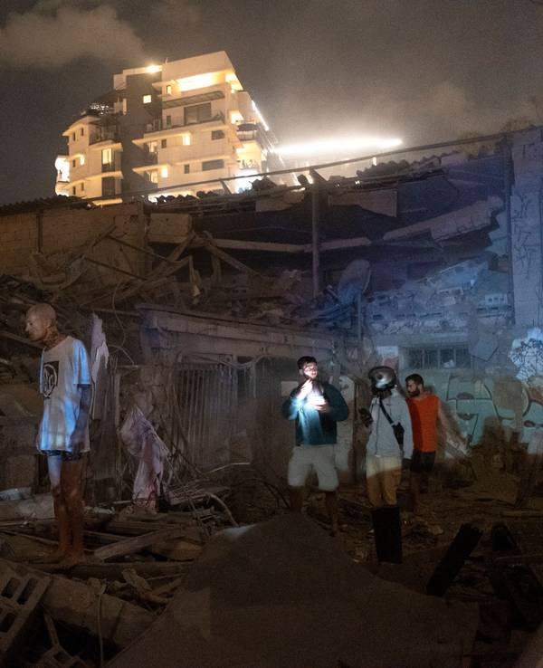 Menschen betrachten den Schaden einer aus dem Gazastreifen abgefeuerten Rakete in Tel Aviv, Israel, Samstag, 7. Oktober 2023.
