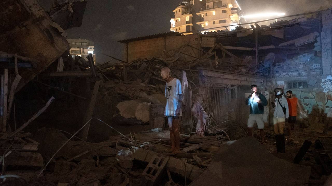Menschen betrachten den Schaden einer aus dem Gazastreifen abgefeuerten Rakete in Tel Aviv, Israel, Samstag, 7. Oktober 2023.