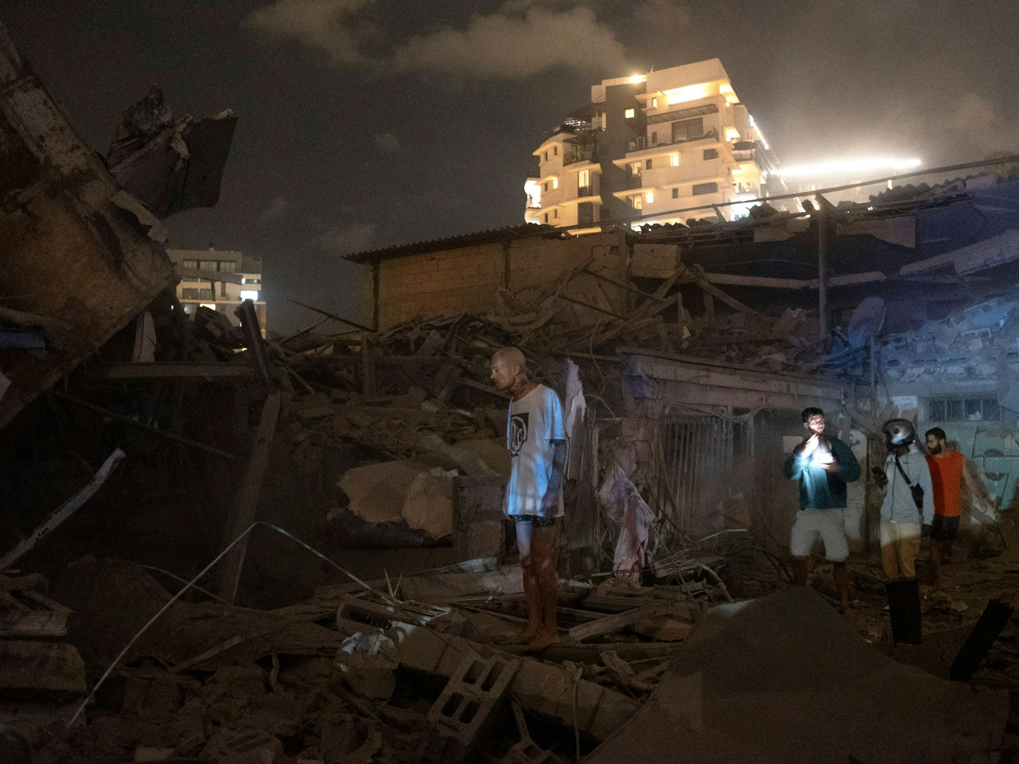 Menschen betrachten den Schaden einer aus dem Gazastreifen abgefeuerten Rakete in Tel Aviv, Israel, Samstag, 7. Oktober 2023.