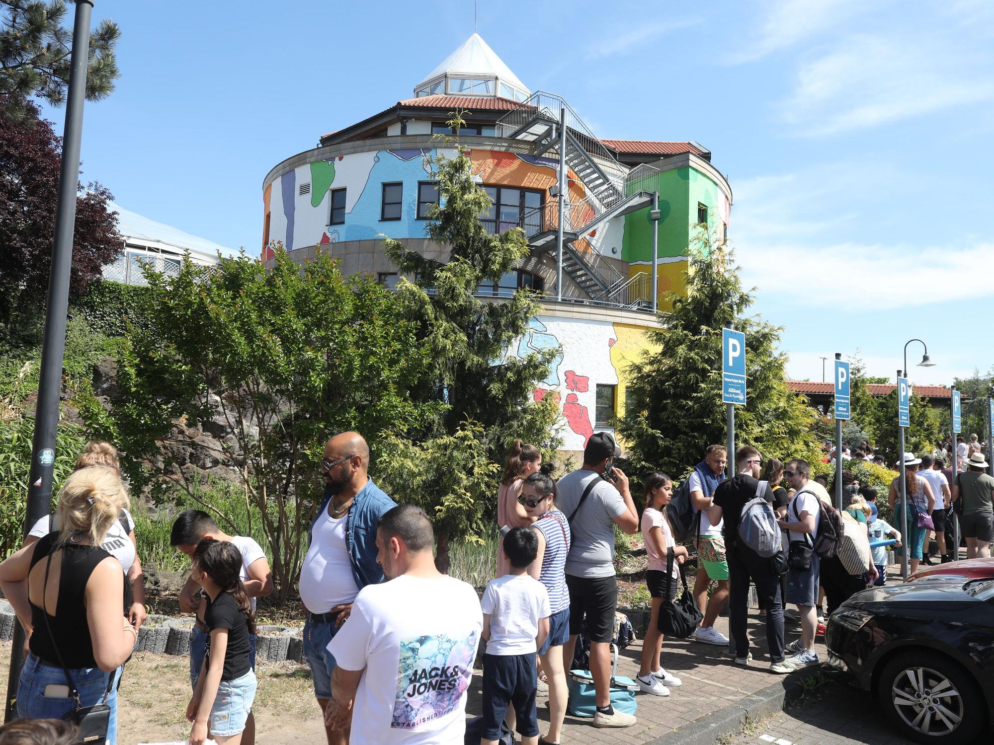 Erwachsene und Kinder stehen vor dem „Aqualand“ Schlange.