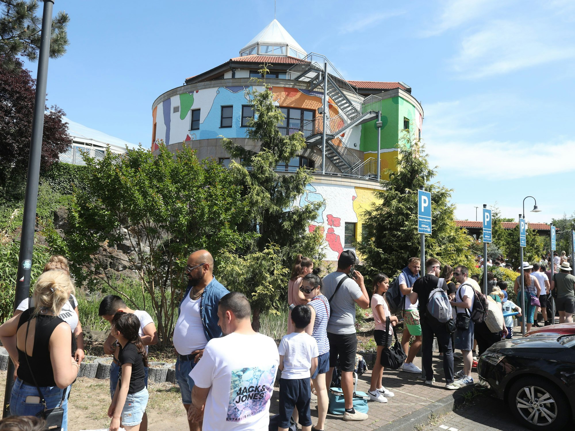 Erwachsene und Kinder stehen vor dem „Aqualand“ Schlange.