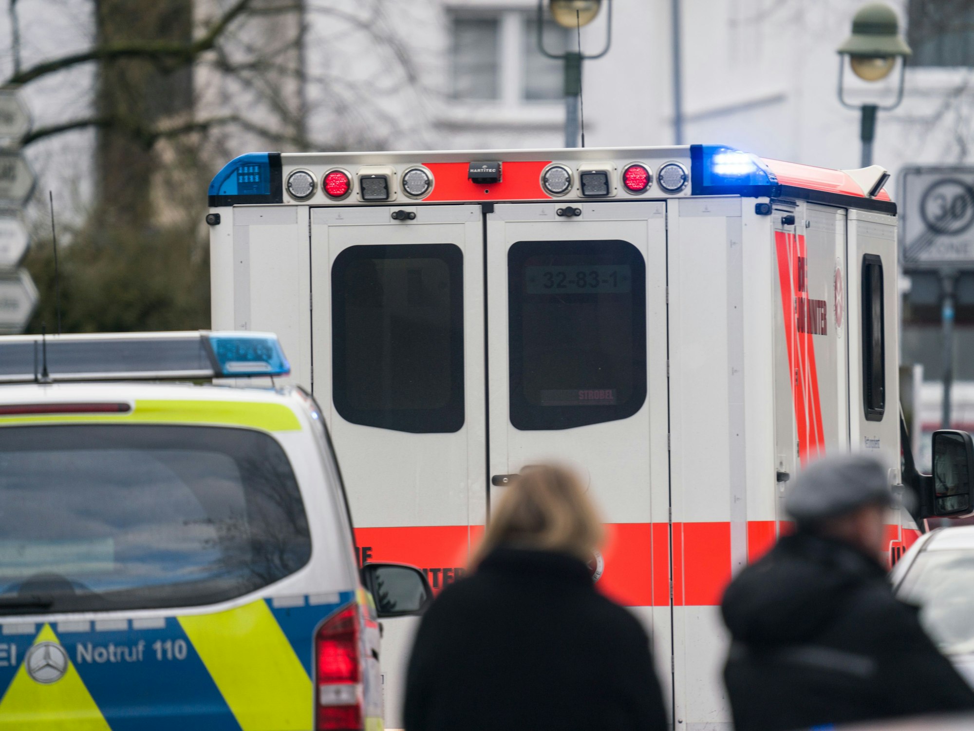 Ein Rettungswagen steht vor einem Streifenwagen.