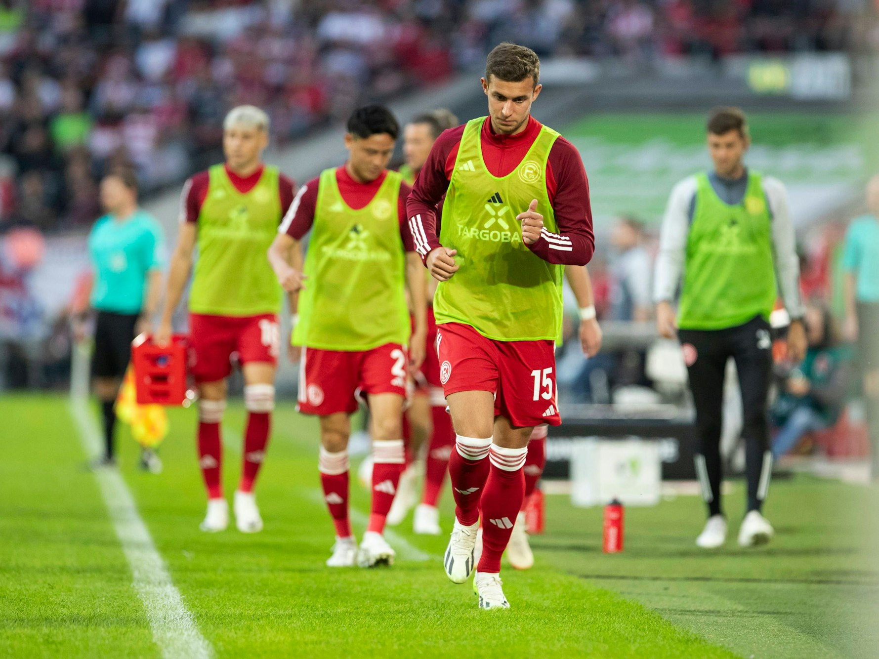 Tim Oberdorf wärmt sich mit seinen Teamkollegen beim Spiel gegen den Karlsruher SC am Seitenrand auf.
