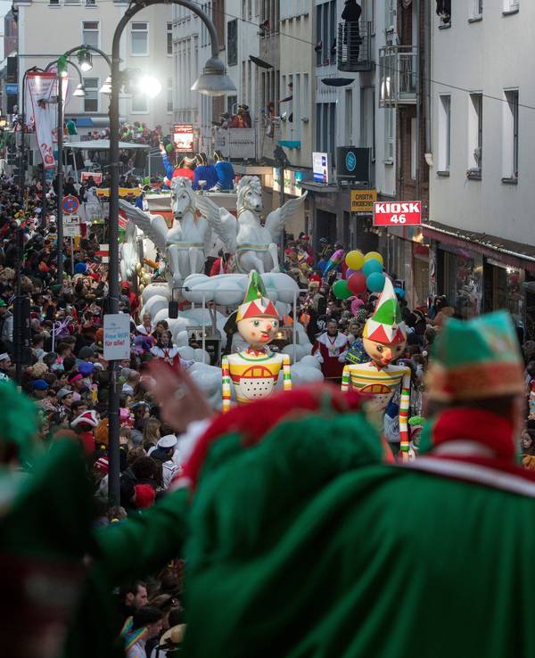 Blick von einer Tribüne auf den Rosenmontagszug, der auf der Kölner Severinstraße entlangläuft.