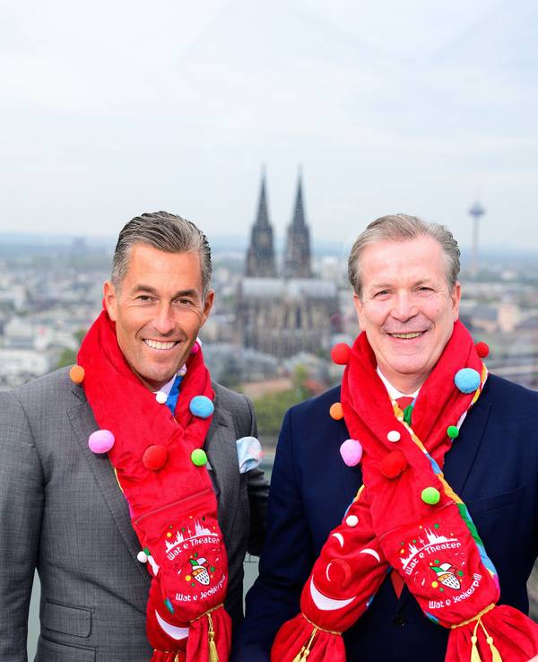 Herbert Geiss und Christoph Kuckelkorn mit dem neuen Mottoschal vor dem Panorama des Kölner Doms.