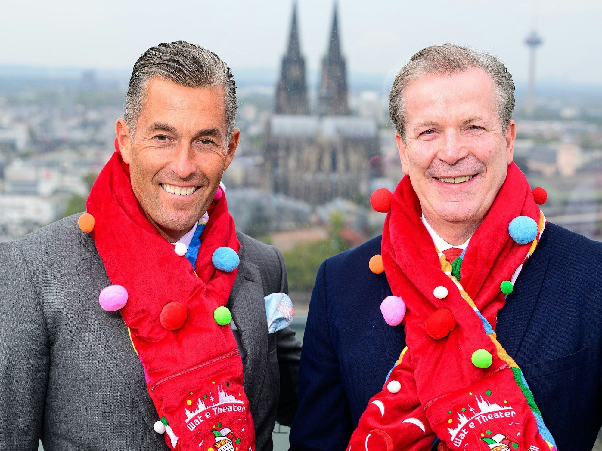 Herbert Geiss und Christoph Kuckelkorn mit dem neuen Mottoschal vor dem Panorama des Kölner Doms.