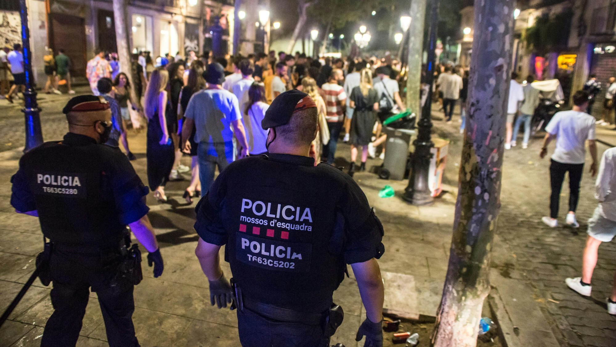 Spanische Polizeikräfte vertreiben junge Menschen, die sich nachts auf der Straße versammelt hatten.