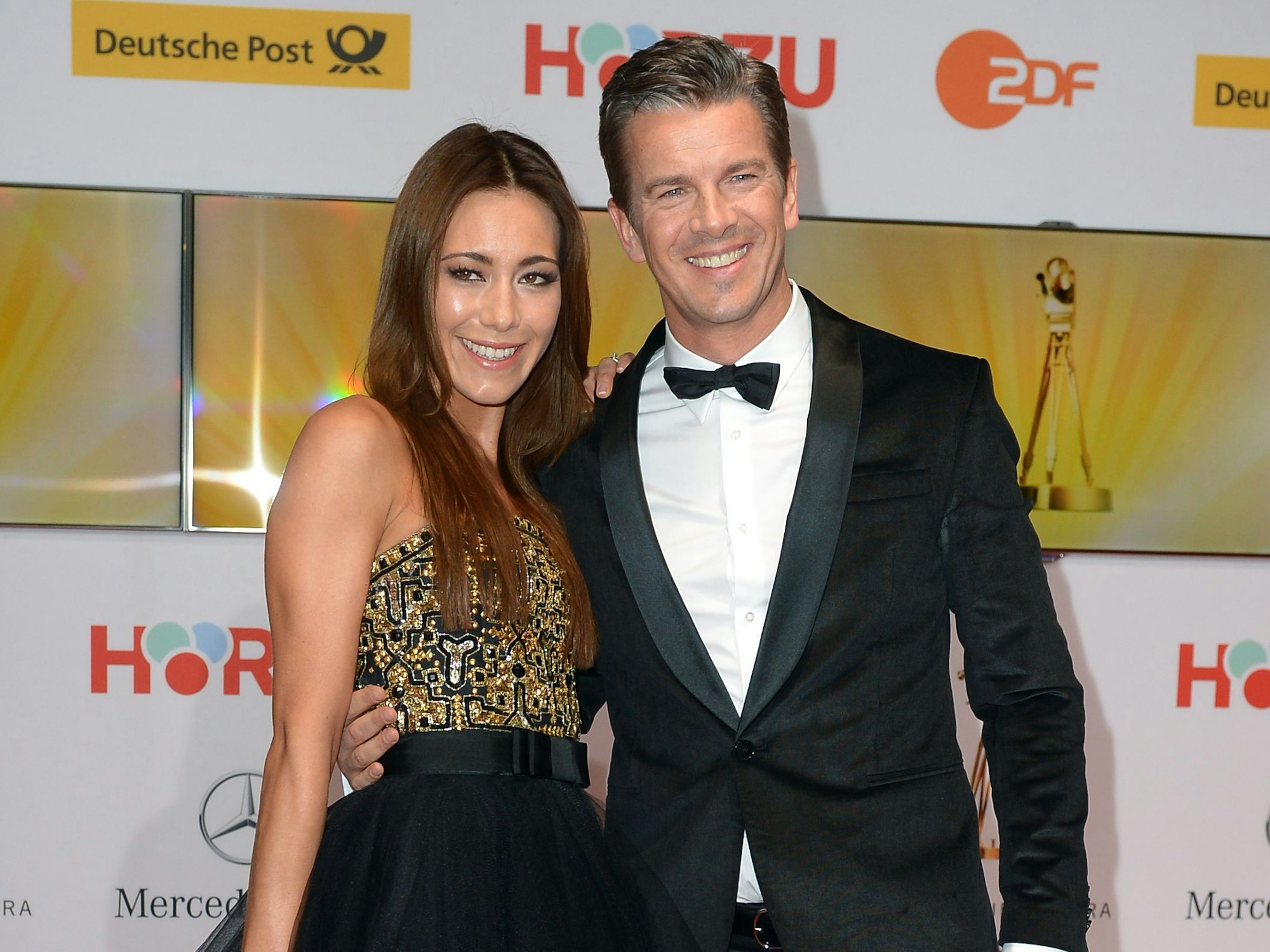 Markus Lanz und Angela Lanz auf dem Roten Teppich. Sie gucken in die Kamera.