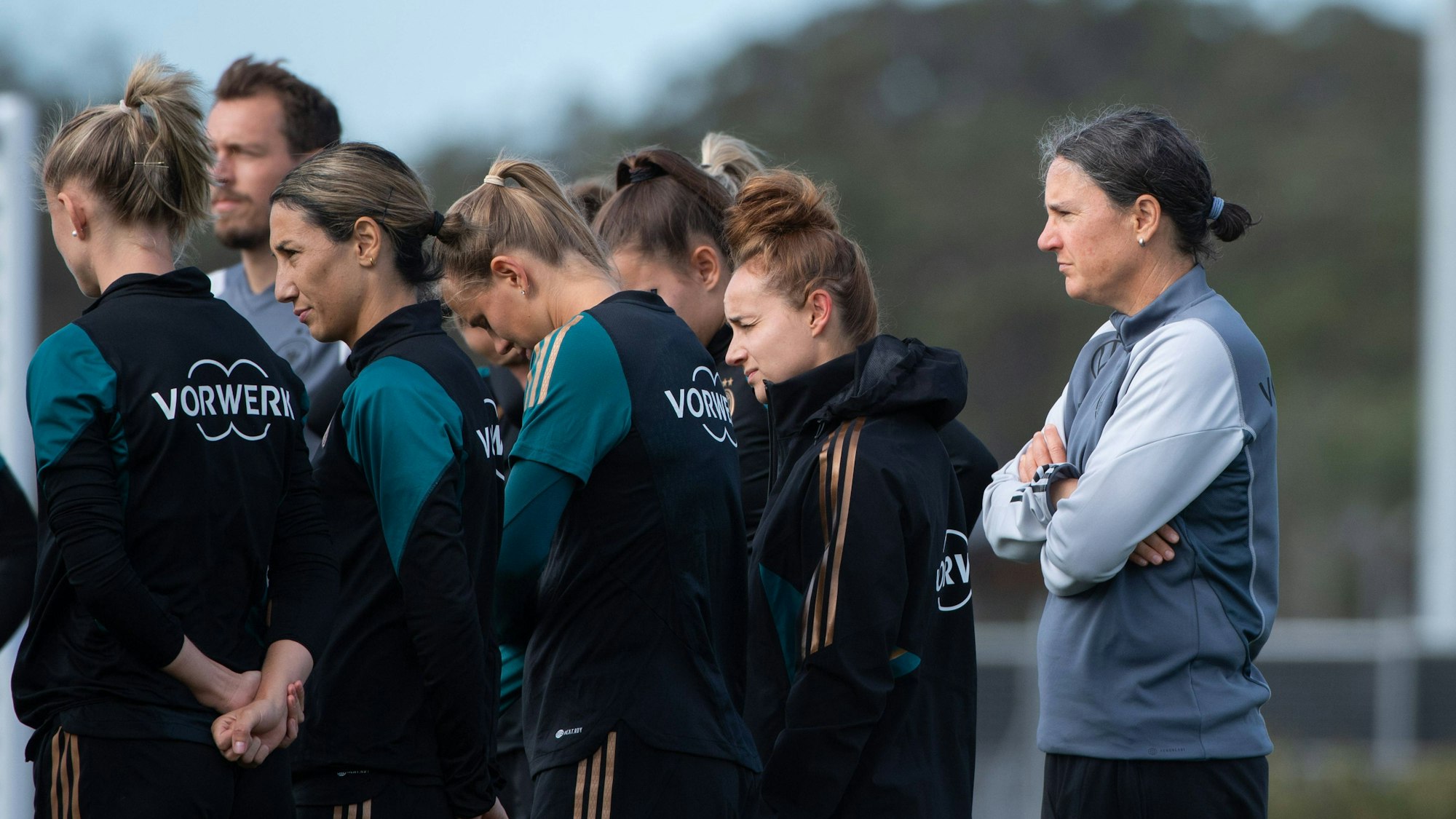 Birgit Prinz hört mit verschränkten Armen zu.