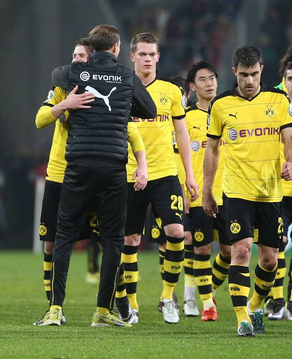 Spieler von Borussia Dortmund gehen vom Platz und werden vom damaligen Trainer Thomas Tuchel umarmt.