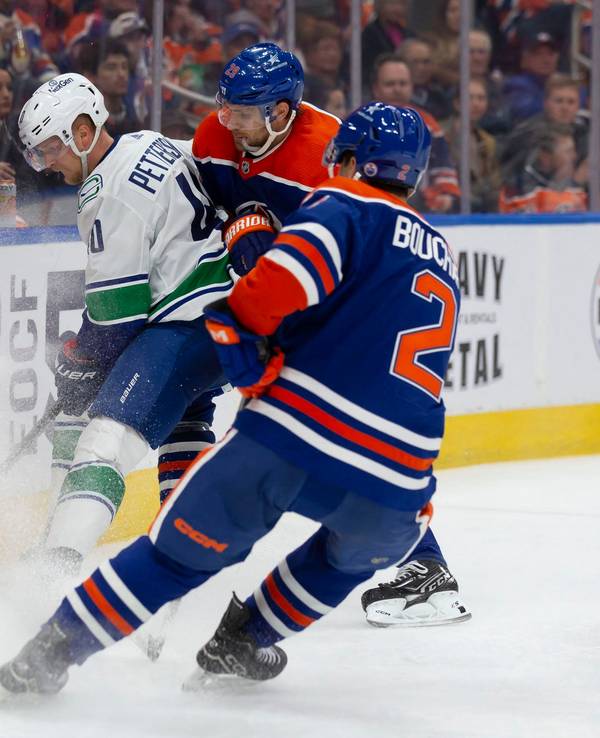 Oilers Leon Draisatil (M.) und Canucks Elias Petterson (l.) im Zweikampf.