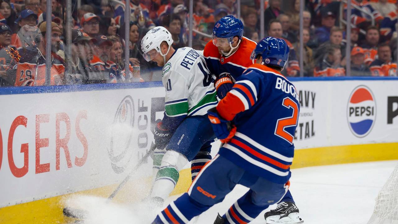 Oilers Leon Draisatil (M.) und Canucks Elias Petterson (l.) im Zweikampf.