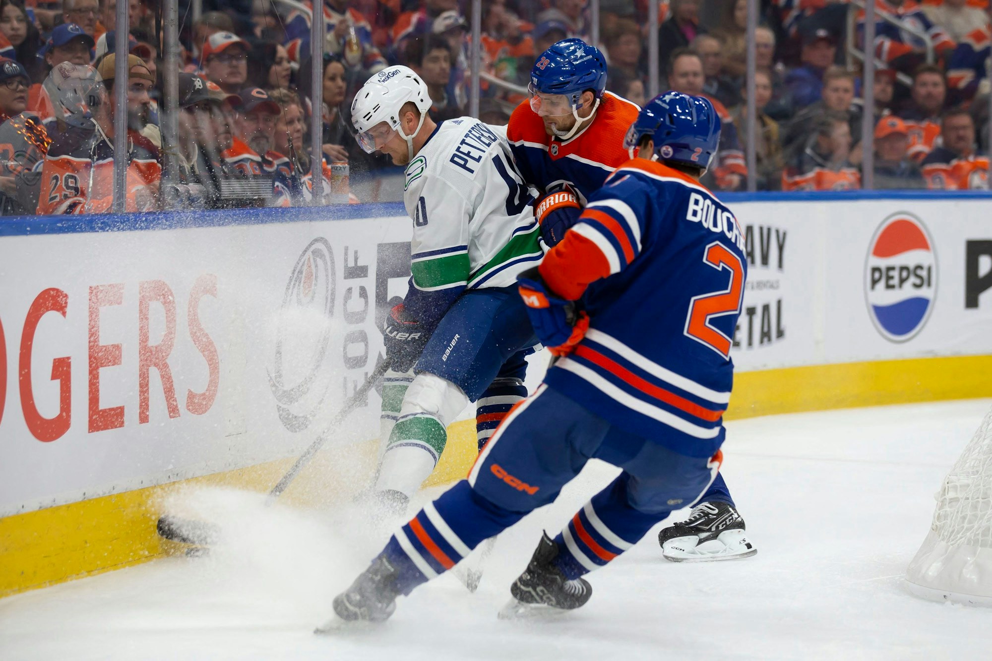 Oilers Leon Draisatil (M.) und Canucks Elias Petterson (l.) im Zweikampf.