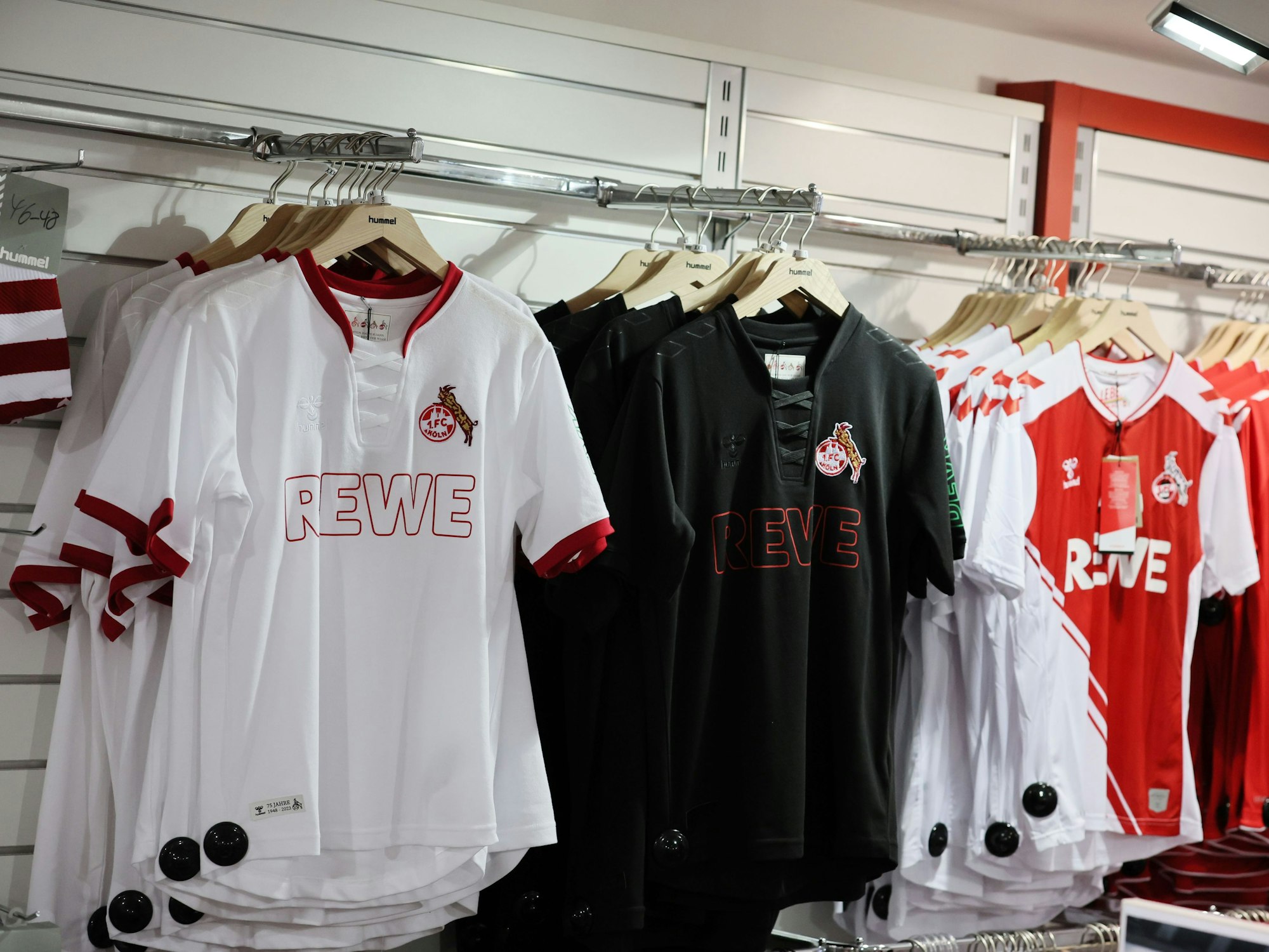 Trikots des 1. FC Köln hängen im Fanshop.