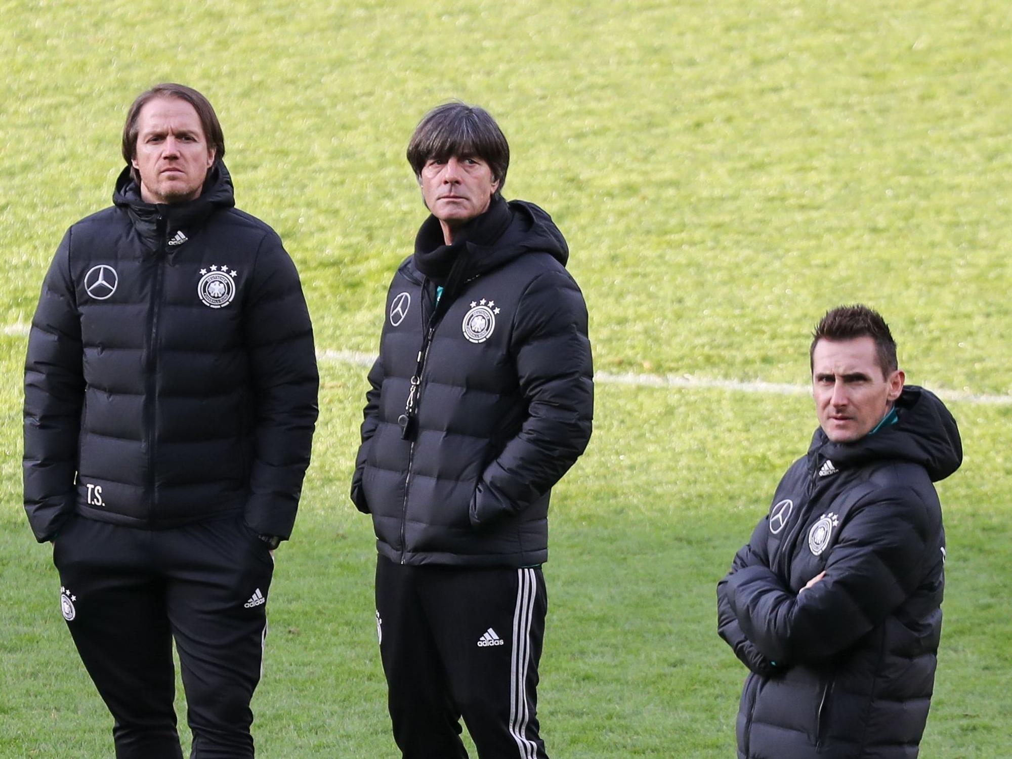 Joachim Löw steht vor einem Testspiel gegen Brasilien mit seinen Assistenten Thomas Schneider und Miroslav Klose auf dem Rasen.