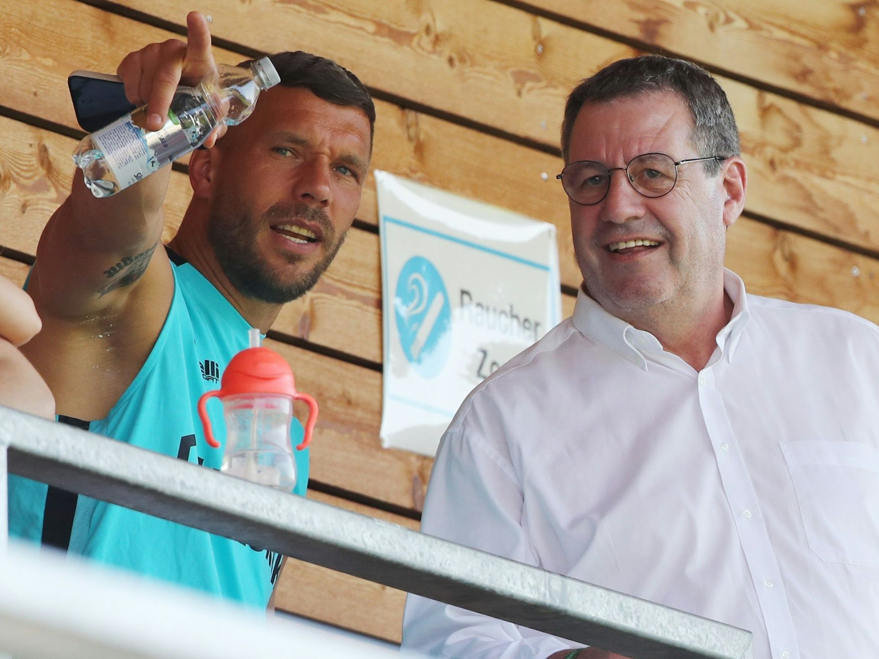 Trainingslager in Maria Alm: 1. FC Köln beim Blitzturnier im Koasastadion gegen Hannover 96 und Gornik Zabrze. Lukas Podolski (Zabrze) und Werner Wolf (1. FC Köln) unterhalten sich auf der Tribüne.