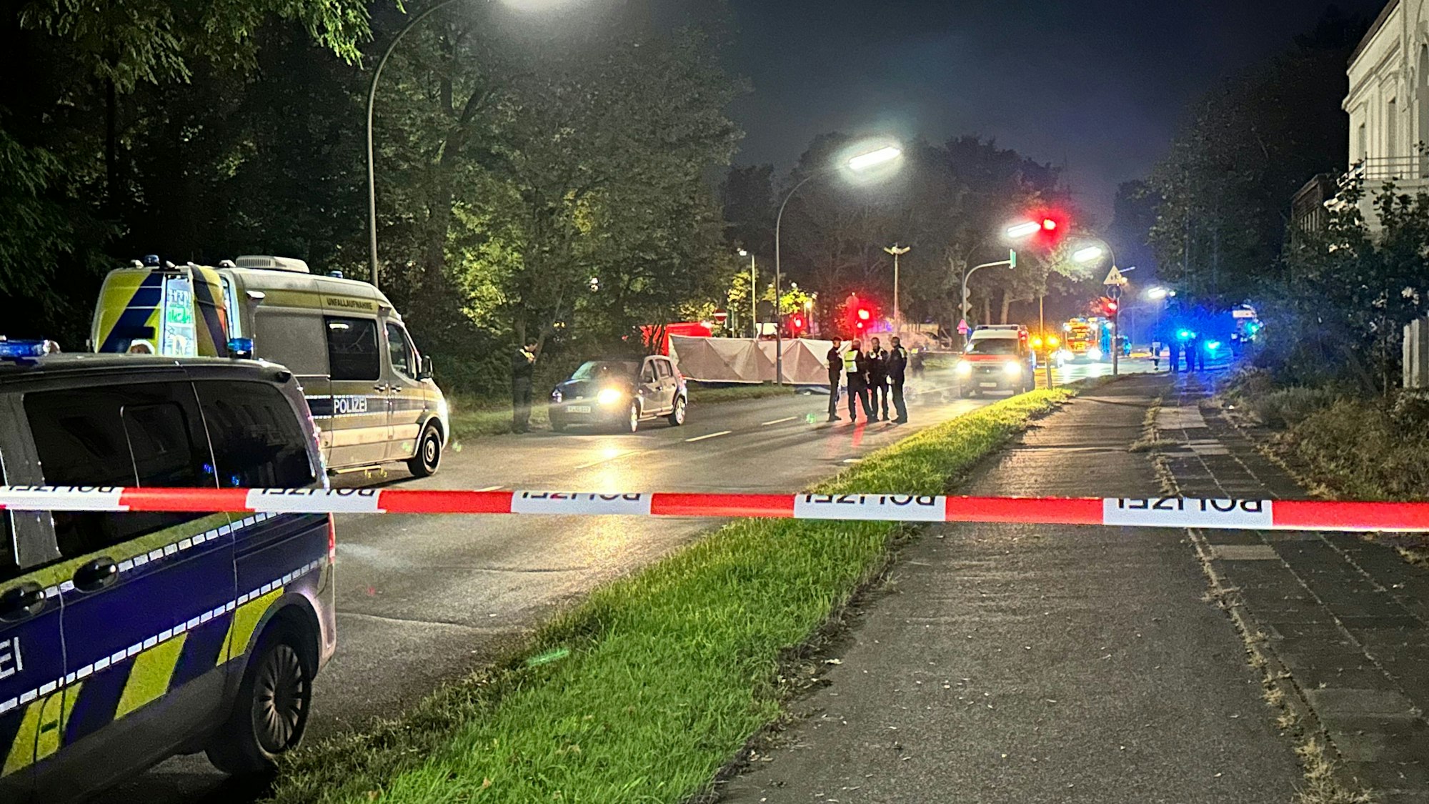 Die Polizei hat eine Straße abgesperrt, dahinter wurde ein Sichtschutz aufgestellt, Einsatzkräfte stehen in der Nähe.