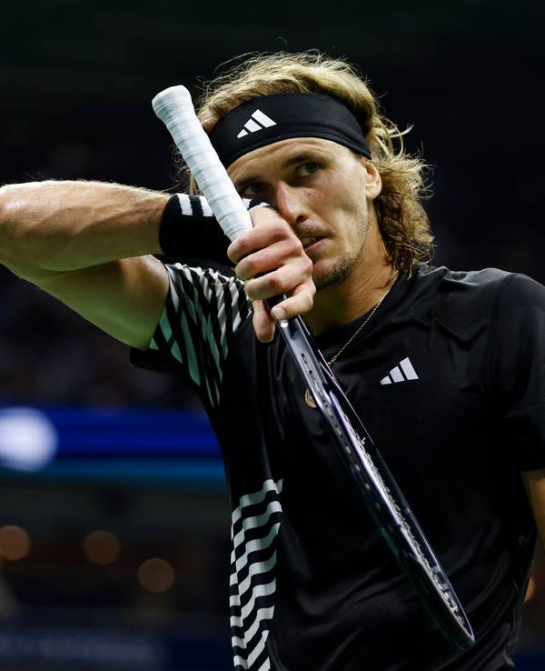 Alexander Zverev wischt sich das Gesicht ab.