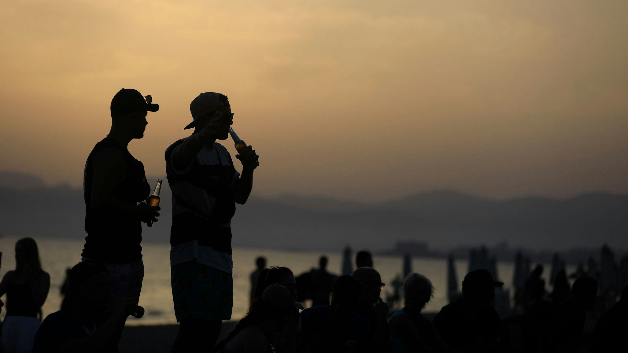 Menschen Anfang Juli am Strand von Arenal, während die Sonne untergeht: Die Zahl der sexuellen Übergriffe auf Mallorca steigt.