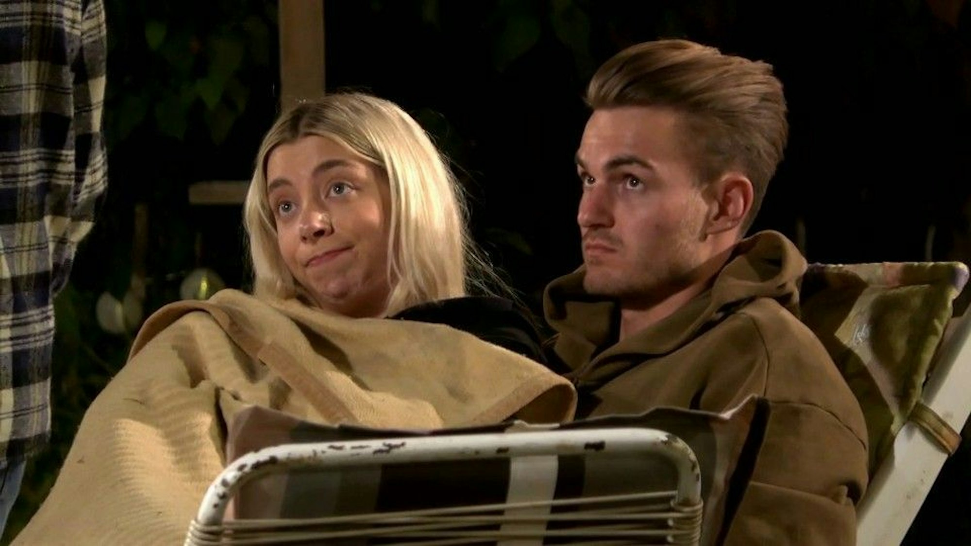 Walentina und Can sitzen zugedeckt am Lagerfeuer von „Das Sommerhaus der Stars“.