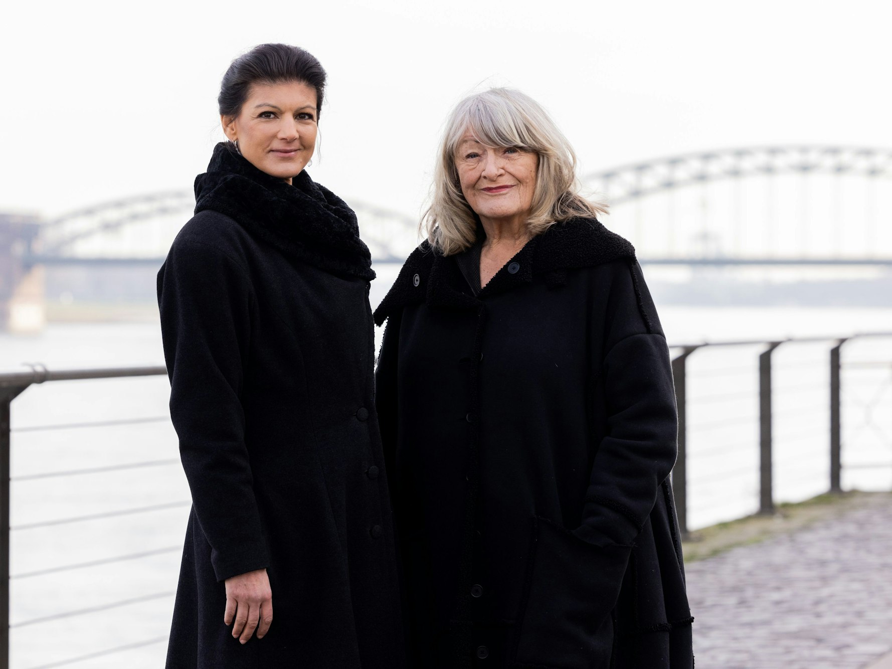 Sahra Wagenknecht und Alice Schwarzer stehen im Rheinauhafen am Rhein.