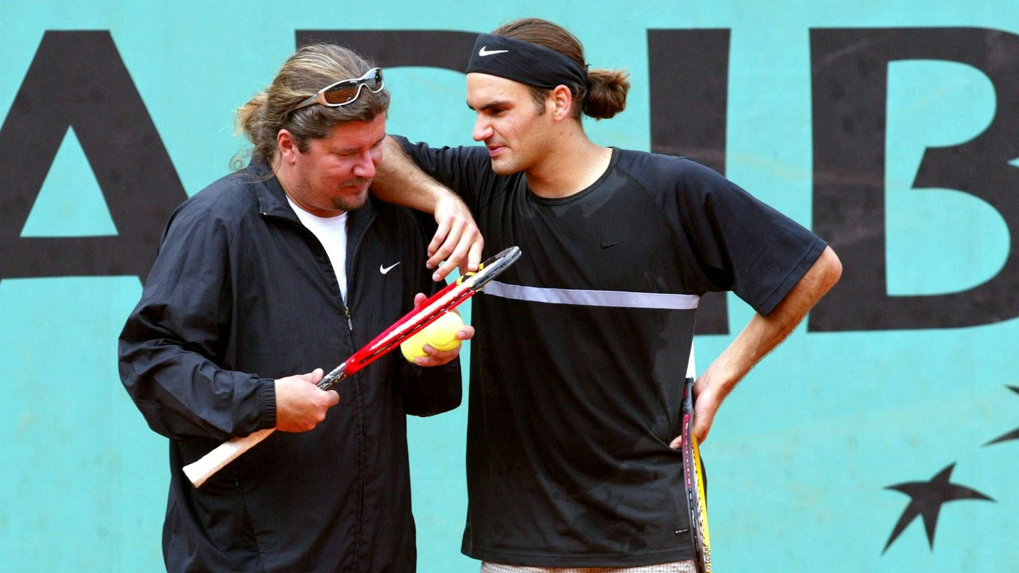 Roger Federer spricht bei einem Training mit seinem Coach Peter Lundgren. Sein rechter Arm liegt auf der Schulter des Schweden.