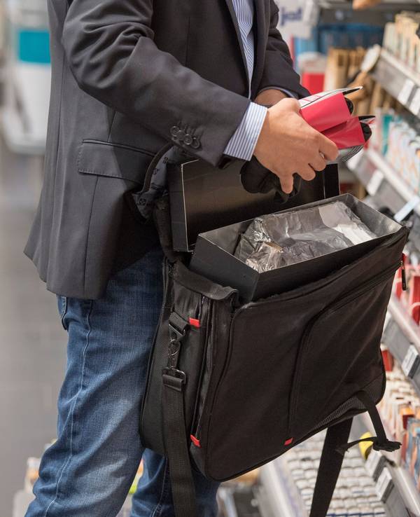 Ein Detektiv von einer Sicherheitsfirma demonstriert in einem Supermarkt, wie Ladendiebe mithilfe eines präparierten Koffers die Sicherungsetiketten an der Ware überlisten können.