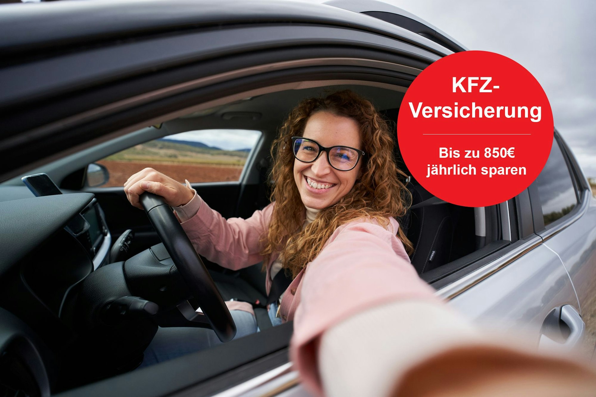 Frau lächelt im Auto und macht Selfie