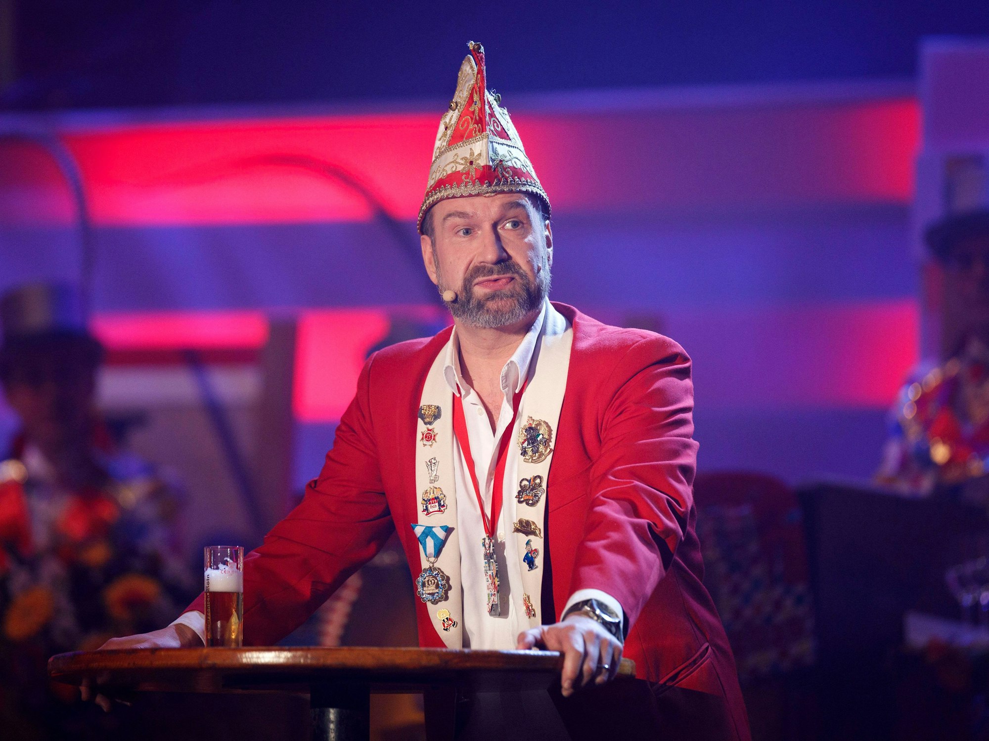 Volker Weininger steht in seiner Rolle als Sitzungspräsident an einem Pult auf der Bühne und präsentiert sein Programm.