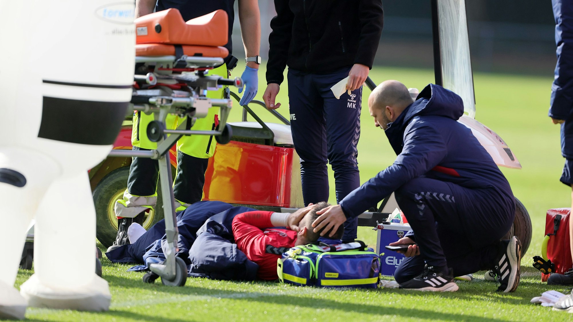 Philipp Pentke liegt nach seinem Trainingsunfall auf dem Rasen. Ein Betreuer kümmert sich um ihn.