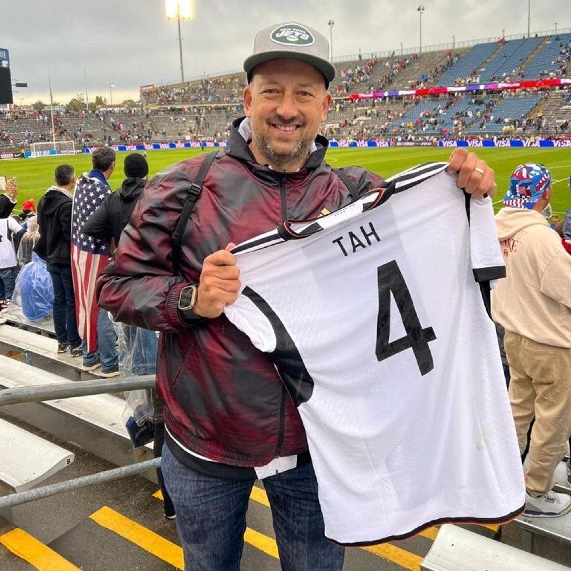 Fortuna-Stadionsprecher André Scheidt posiert in Hartford mit dem Trikot von Jonathan Tah.