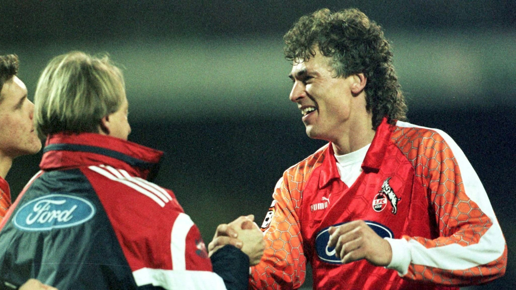 Toni Polster klatscht nach einem Spiel des 1. FC Köln mit Trainer Lorenz-Günther Köstner ab.