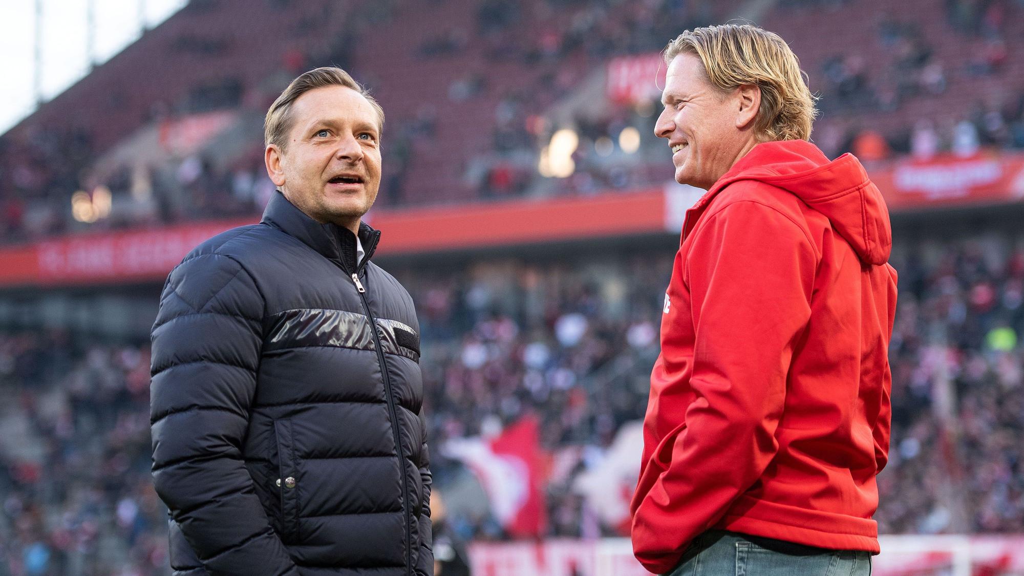 Horst Heldt und Markus Gisdol unterhalten sich gut gelaunt vor einem Spiel des 1. FC Köln im Rhein-Energie-Stadion