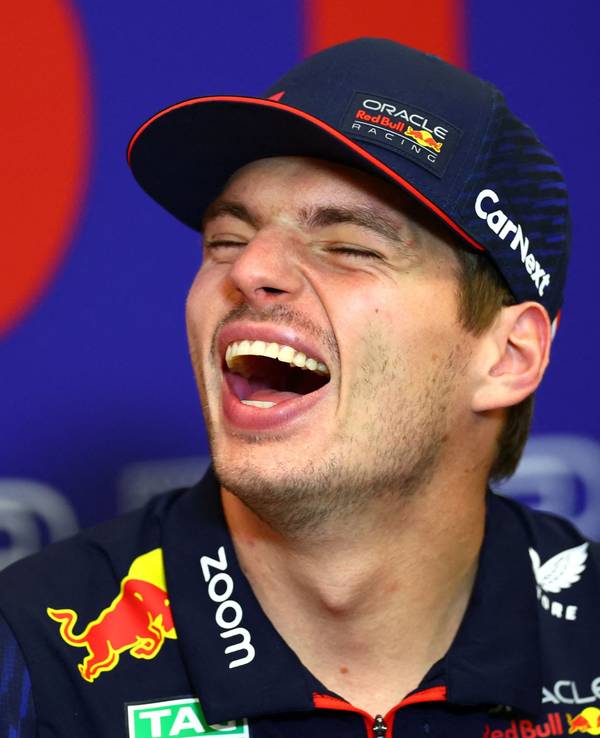 Max Verstappen lacht bei einer Pressekonferenz.