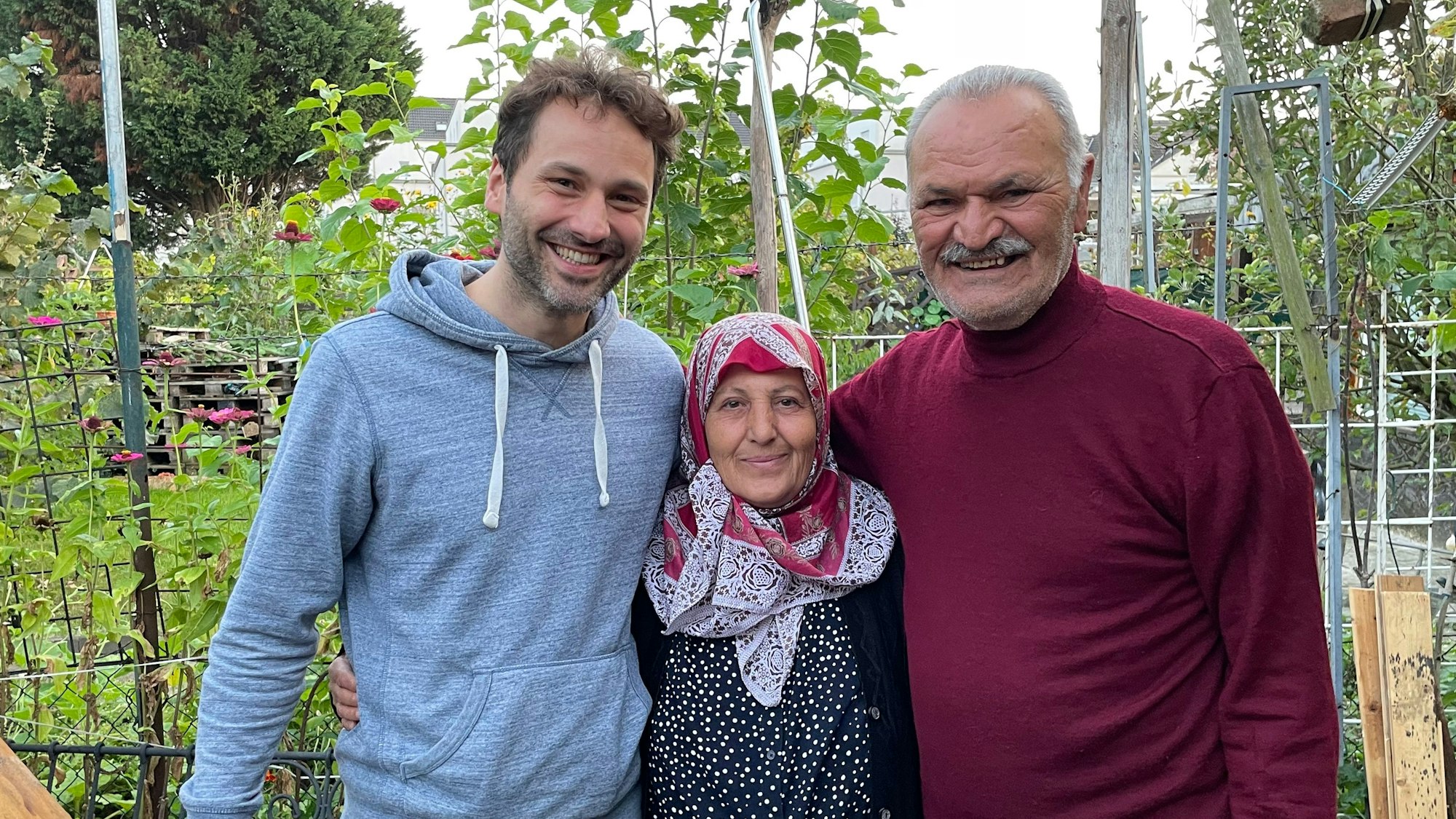 Seyfo Kurt mit seiner Frau und einem anderen Mann im eigenen Garten.